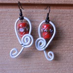boucles blanches, perle rouge